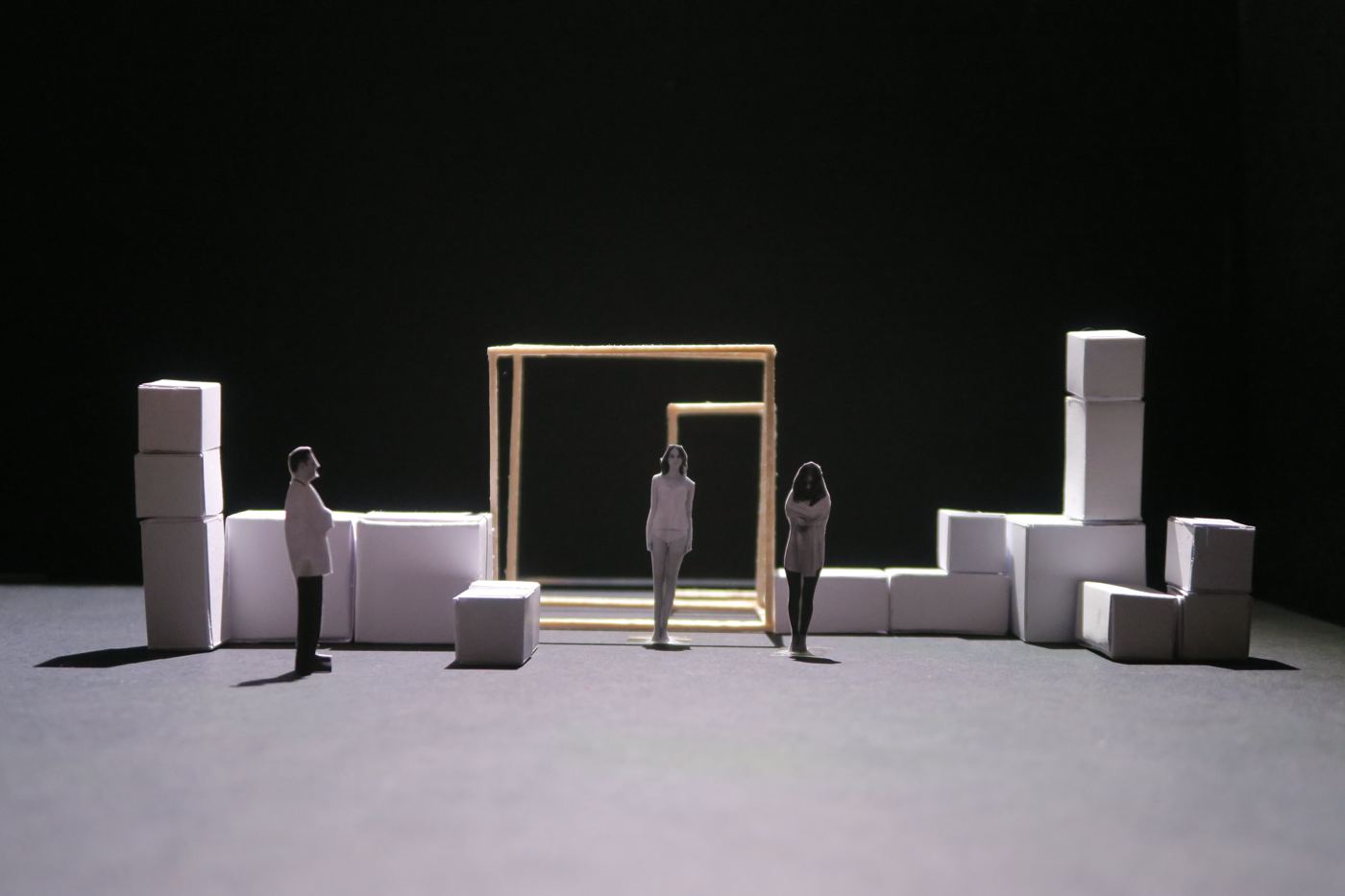 Scale model under red and orange light, three figures between cubes